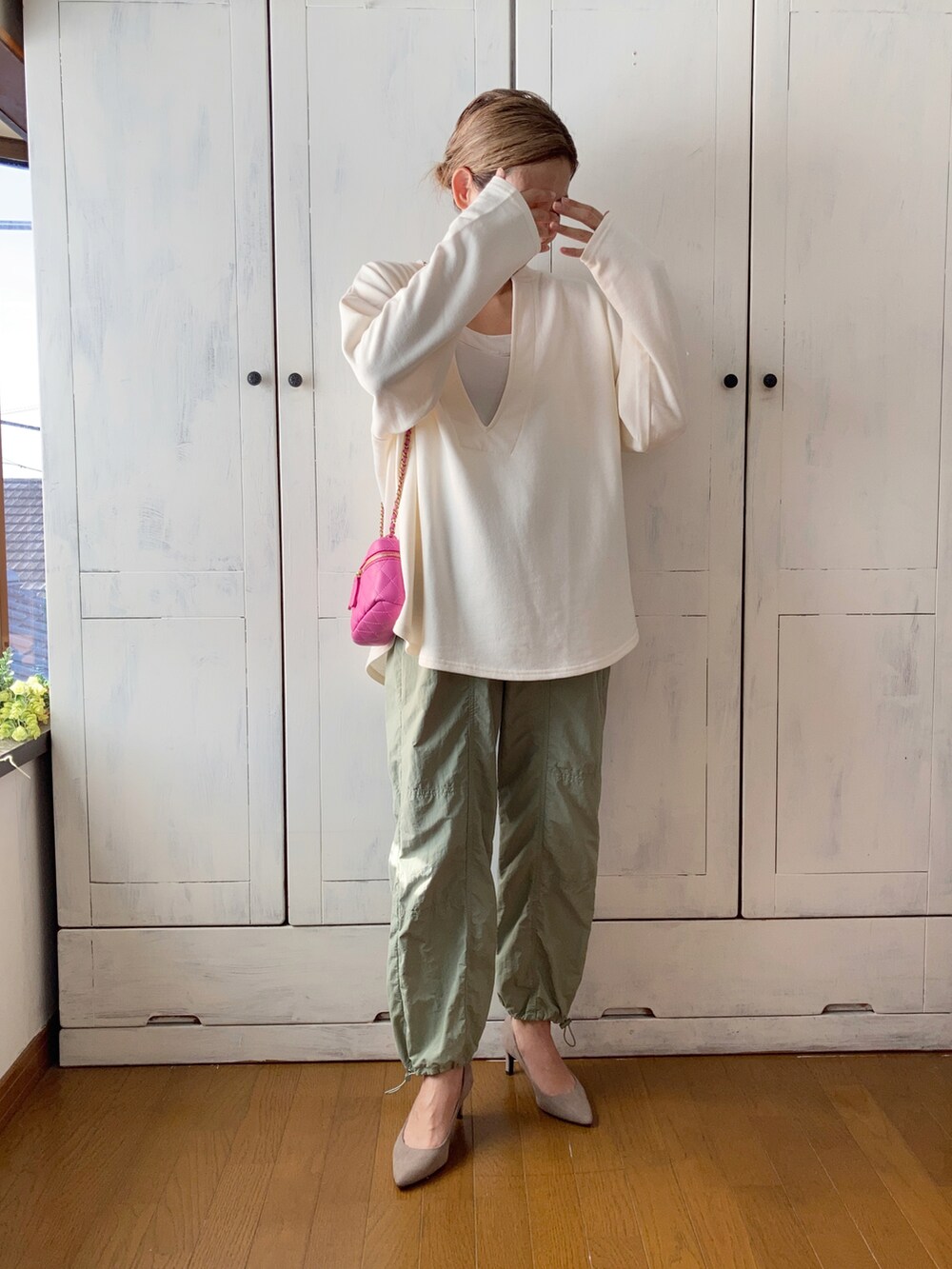 ホワイト系のスウェット、グリーン系のその他パンツ、ピンク系のショルダーバッグを着用したレディースの秋コーディネートの2枚目の写真