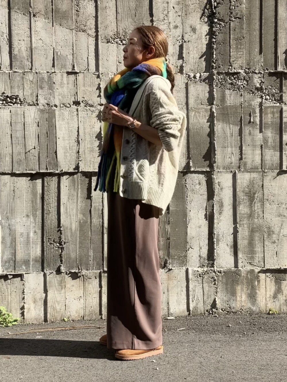 ブラウン系のサロペット/オーバーオール、ホワイト系のTシャツ/カットソー、ホワイト系のカーディガン/ボレロを着用したレディースの秋コーディネートの4枚目の写真