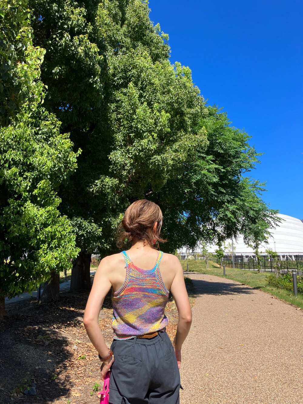 オレンジ系のその他トップス、ピンク系のショルダーバッグ、ブラック系のカーゴパンツを着用したレディースの夏コーディネートの3枚目の写真