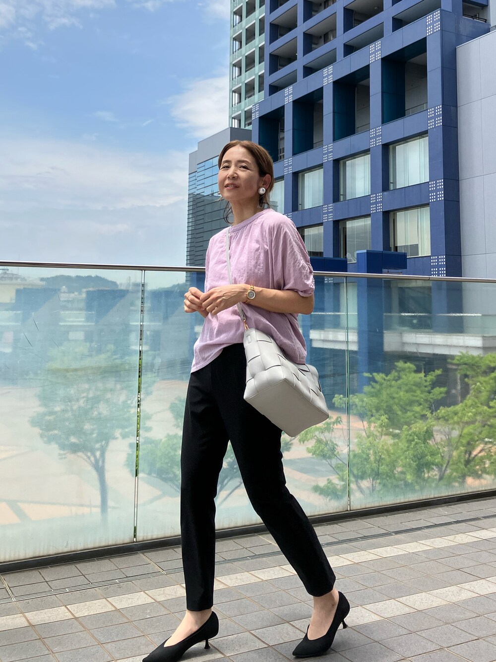 グレー系のハンドバッグ、パープル系のシャツ/ブラウス、ブラック系のパンツを着用したレディースの夏コーディネートの2枚目の写真