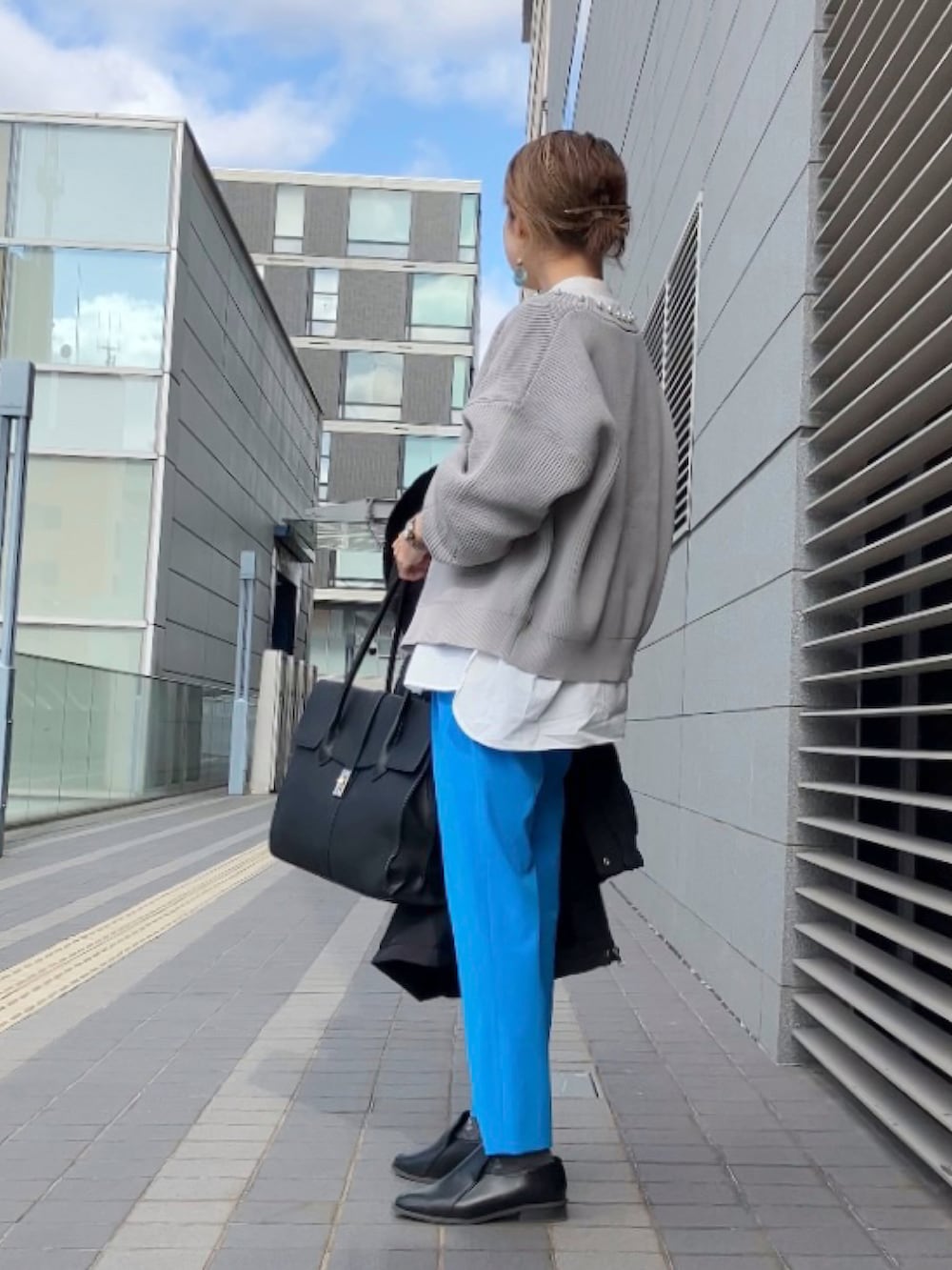 グレー系のカーディガン/ボレロ、ブルー系のその他パンツ、ブラック系のブルゾンを着用したレディースの冬コーディネートの2枚目の写真