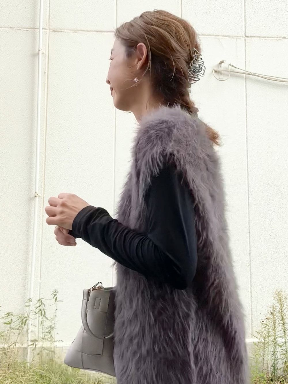 グレー系のニット/セーター、ブラック系のTシャツ/カットソー、グレー系のハンドバッグを着用したレディースの秋コーディネートの2枚目の写真