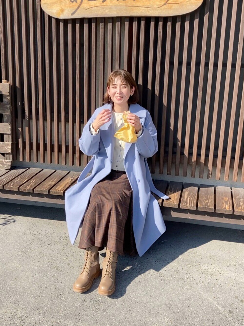 ホワイト系のカーディガン/ボレロ、ブラウン系のスカート、ブラウン系のブーツを着用したレディースの冬コーディネートの2枚目の写真