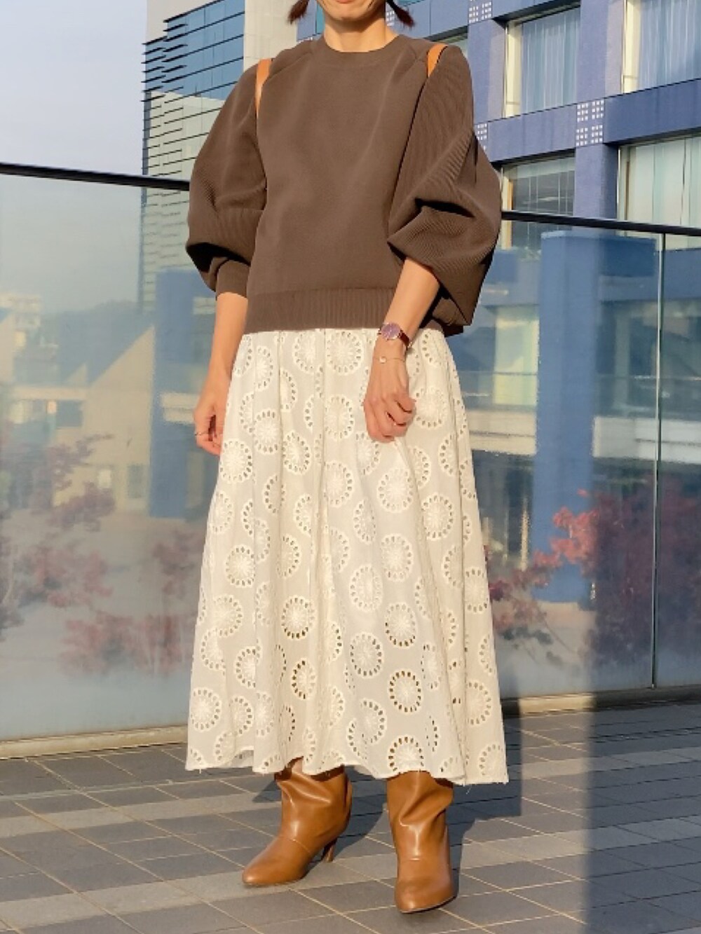 ブラウン系のニット/セーター、イエロー系のバックパック/リュック、ホワイト系のワンピース/ドレスを着用したレディースの秋コーディネートの4枚目の写真