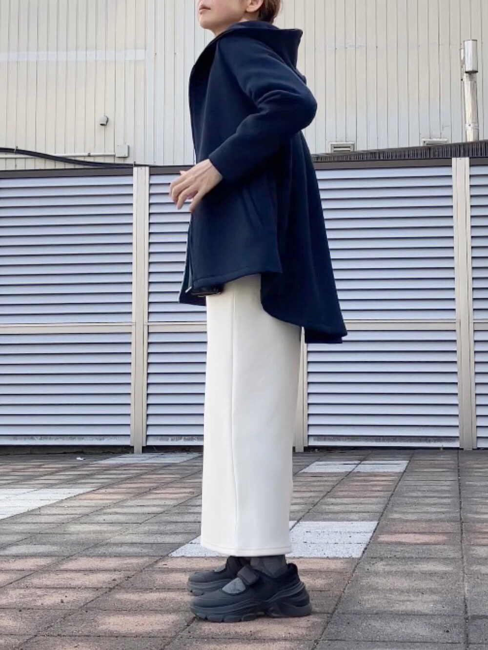 ブルー系のパーカー、ホワイト系のジャンパースカート、ブルー系のシャツ/ブラウスを着用したレディースの春コーディネートの2枚目の写真