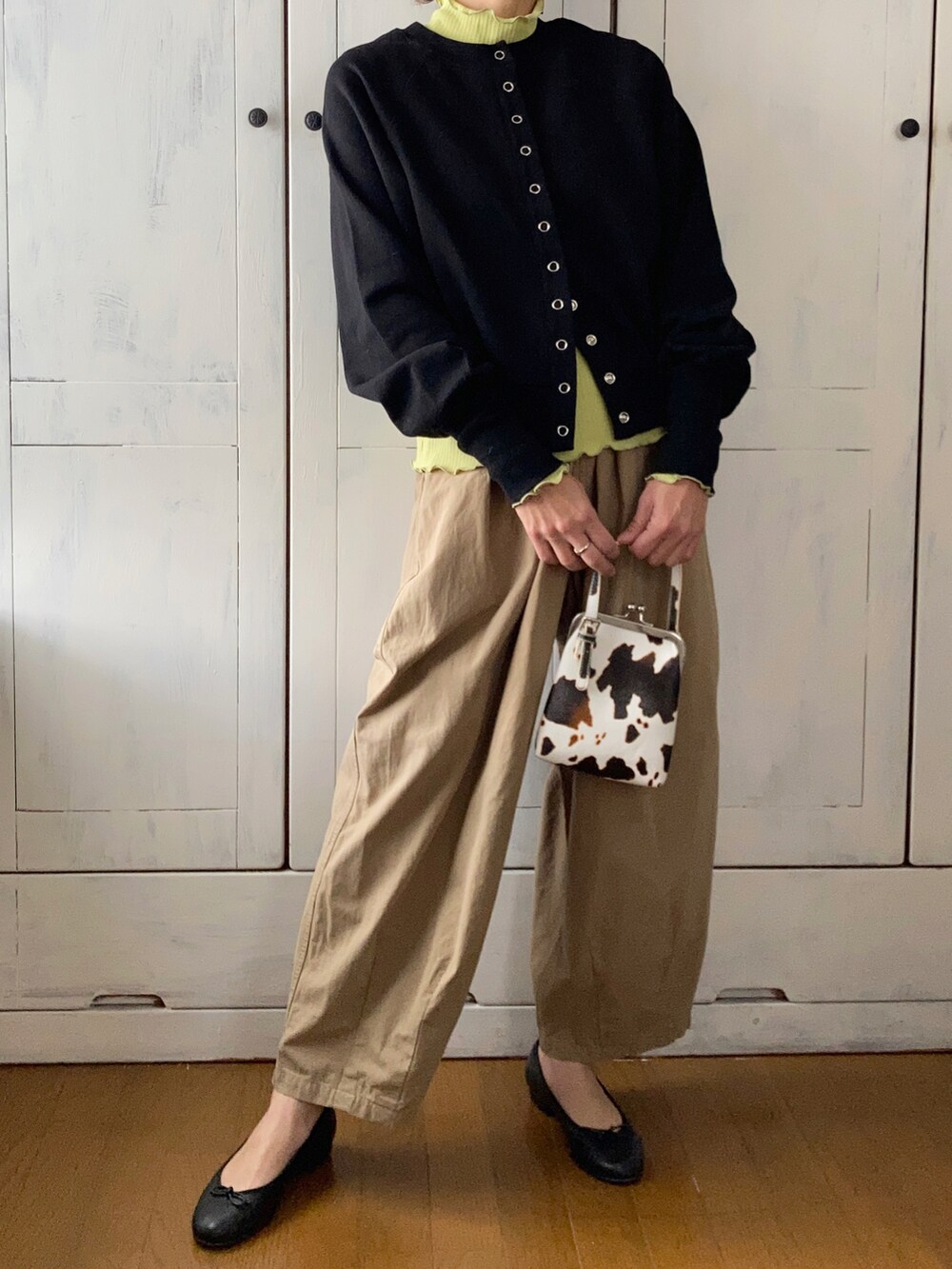 ブラック系のスウェット、グリーン系のTシャツ/カットソー、ベージュ系のチノパンツを着用したレディースの冬コーディネートの2枚目の写真