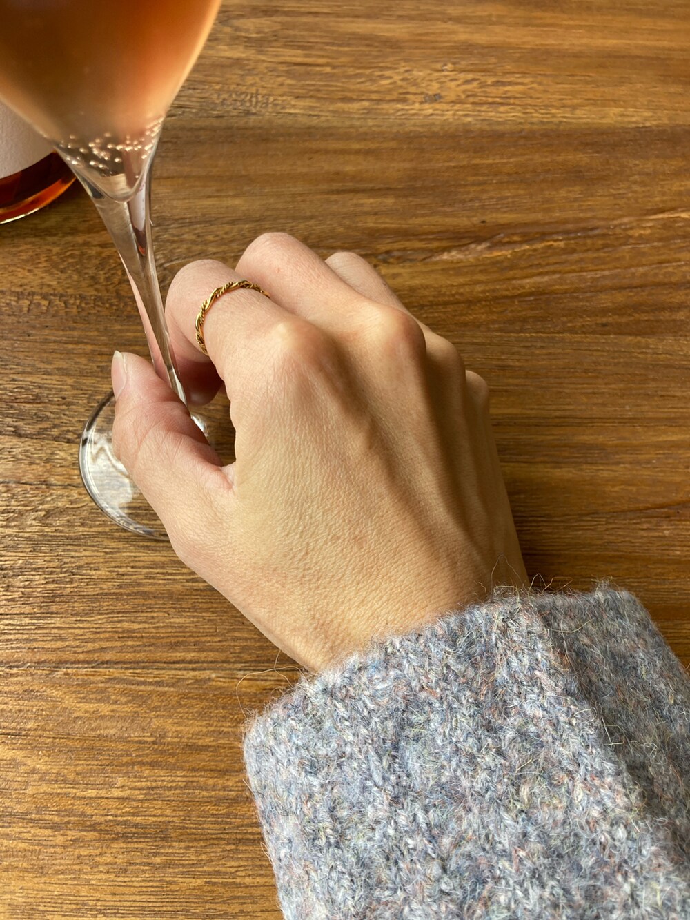 グレー系のニット/セーター、ブラック系のダウンジャケット/コート、オレンジ系のスカートを着用したレディースの冬コーディネートの5枚目の写真