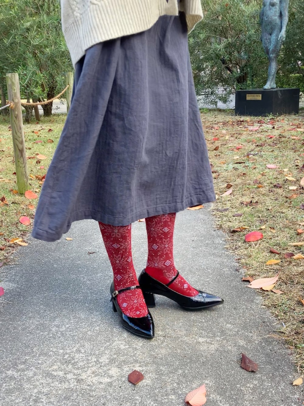 ホワイト系のカーディガン/ボレロ、グレー系のワンピース/ドレス、ブラック系のシューズを着用したレディースの秋コーディネートの5枚目の写真