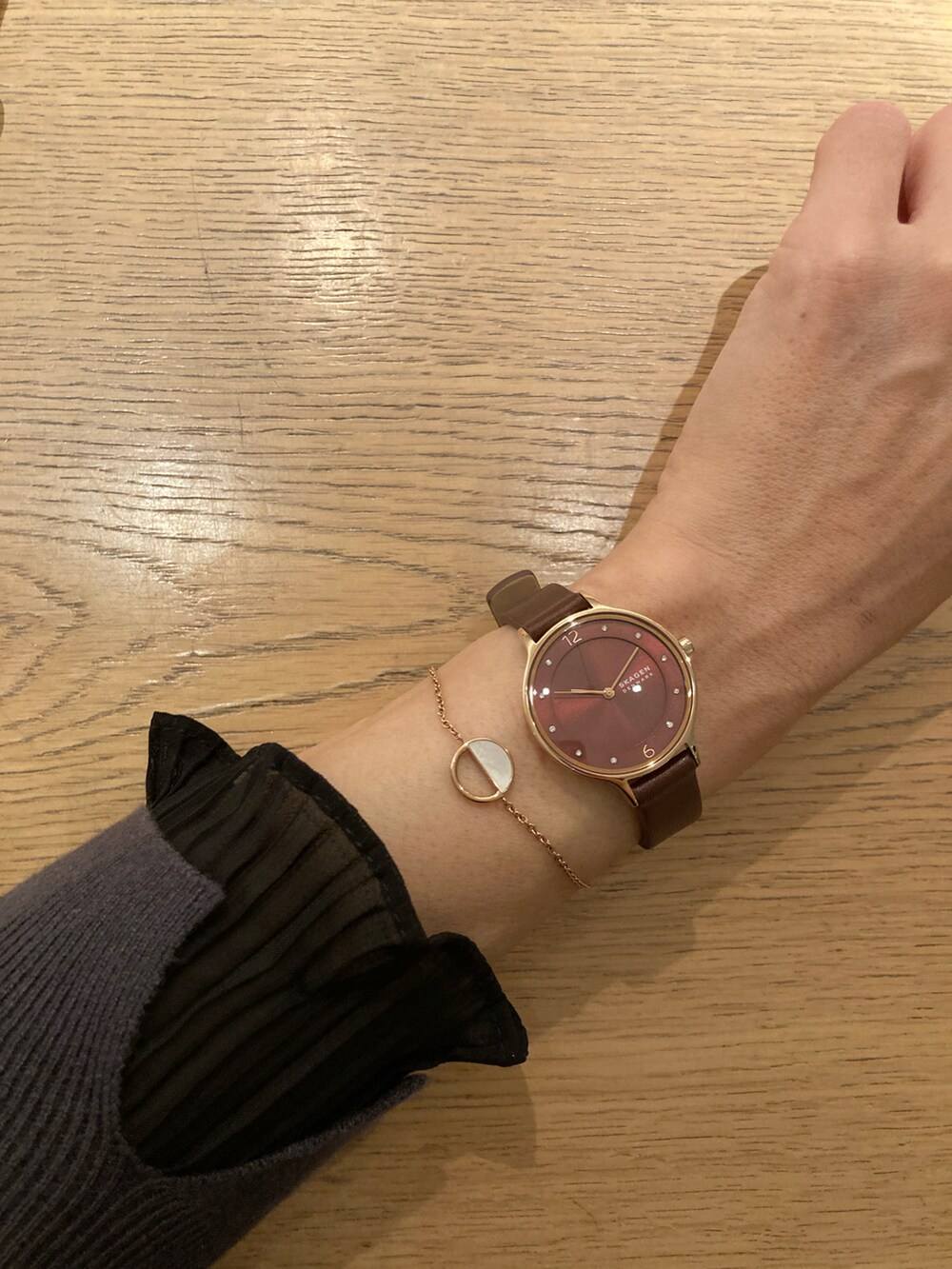 ブラック系のステンカラーコート、グレー系のニット/セーター、グレー系のショルダーバッグを着用したレディースの秋コーディネートの4枚目の写真