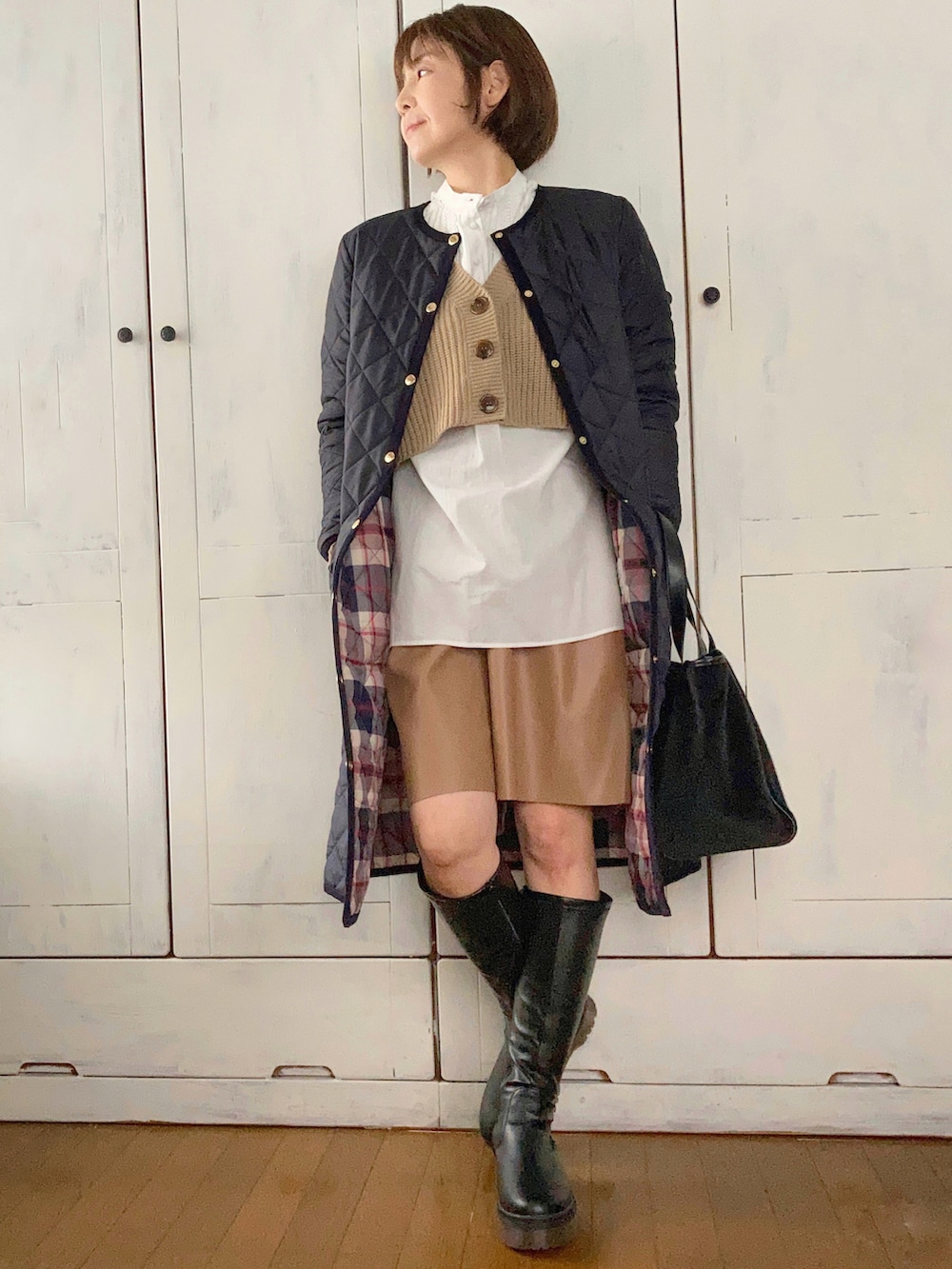 ブルー系のノーカラーコート、ベージュ系のカーディガン/ボレロ、ホワイト系のシャツ/ブラウスを着用したレディースの秋コーディネートの3枚目の写真