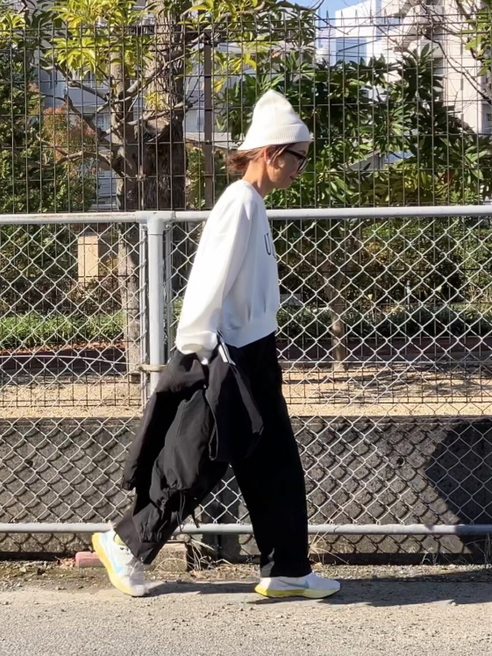 ホワイト系のスウェット、ブラック系のスウェットパンツ、ブラック系のブルゾンを着用したレディースの冬コーディネートの5枚目の写真