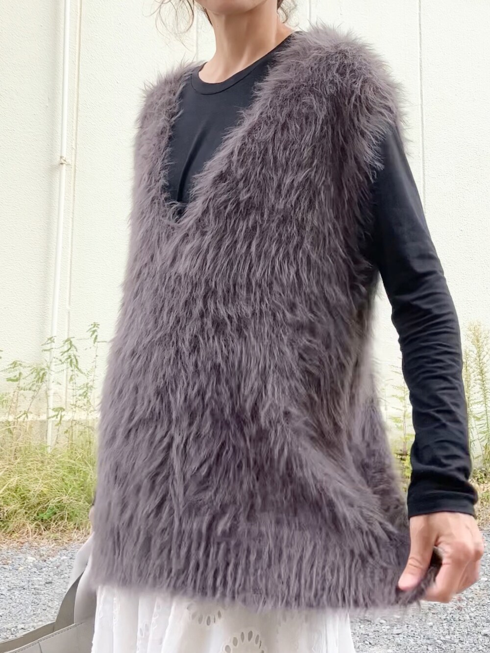 グレー系のニット/セーター、ブラック系のTシャツ/カットソー、グレー系のハンドバッグを着用したレディースの秋コーディネートの4枚目の写真