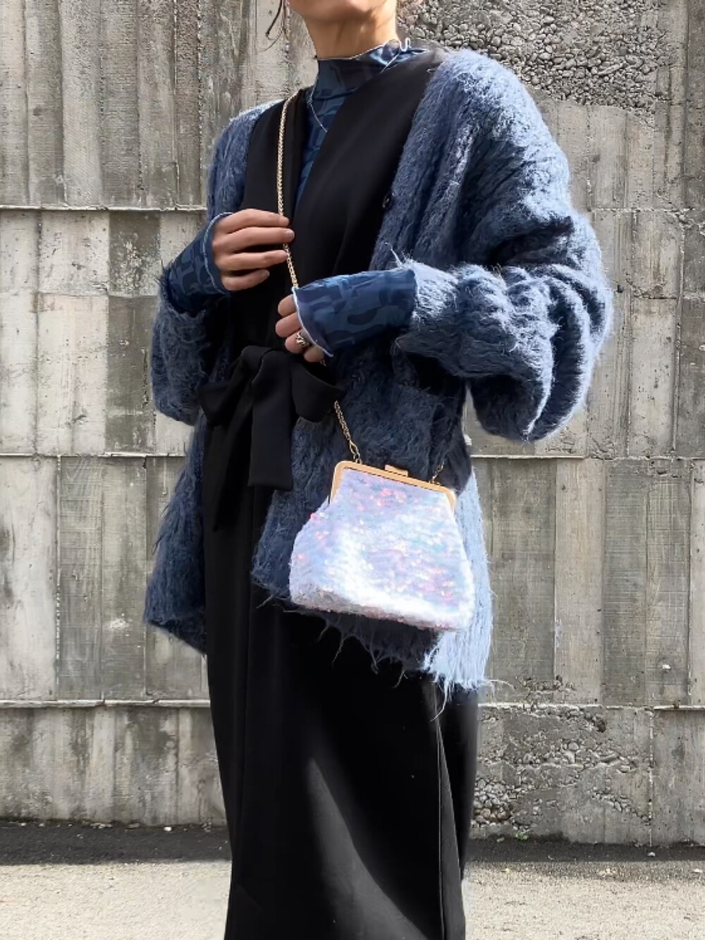 ブルー系のTシャツ/カットソー、ブラック系のジャンパースカート、ブルー系のカーディガン/ボレロを着用したレディースの冬コーディネートの2枚目の写真