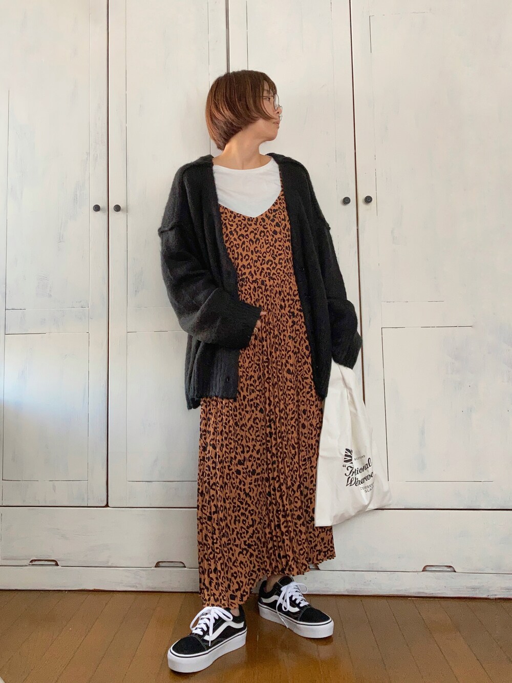 ブラウン系のワンピース、ブラック系のカーディガン/ボレロ、ブラック系のスニーカーを着用したレディースの秋コーディネートの2枚目の写真