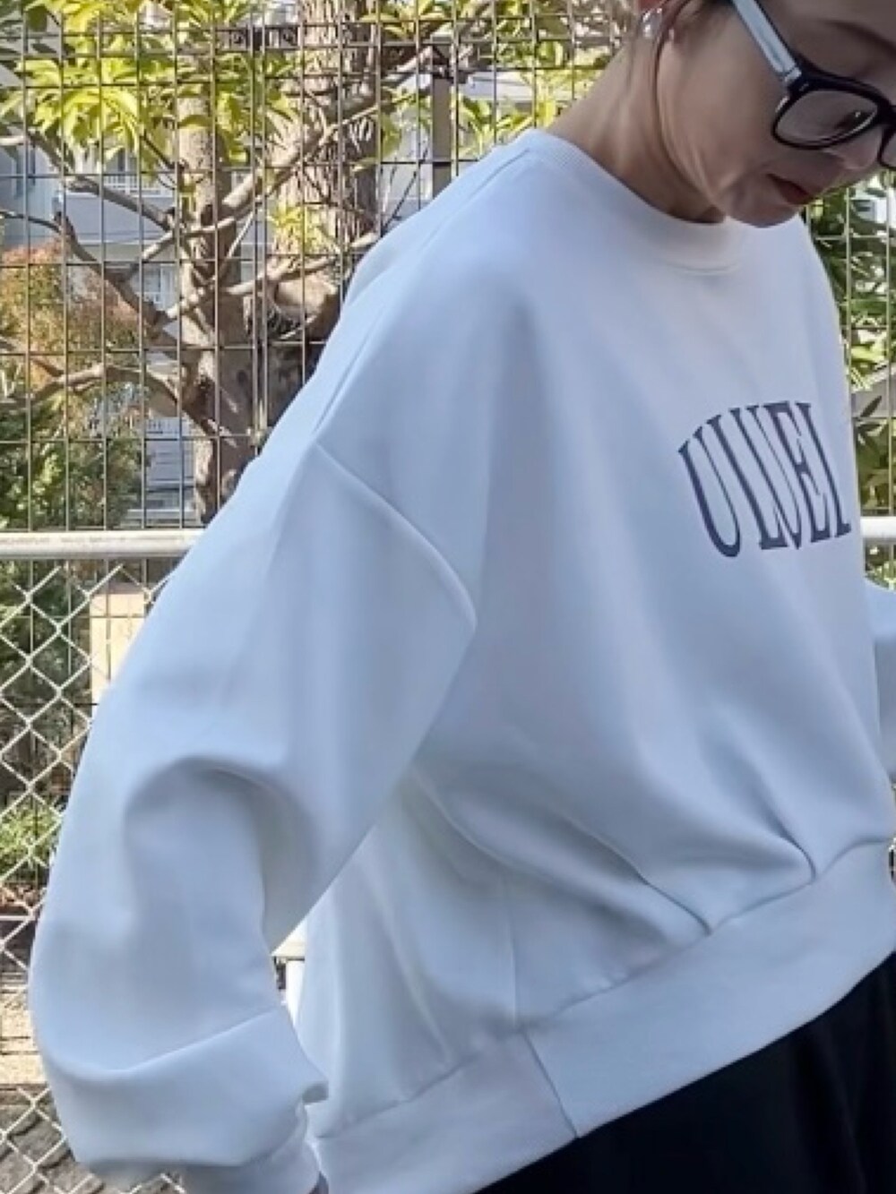 ホワイト系のスウェット、ブラック系のスウェットパンツ、ブラック系のブルゾンを着用したレディースの冬コーディネートの2枚目の写真