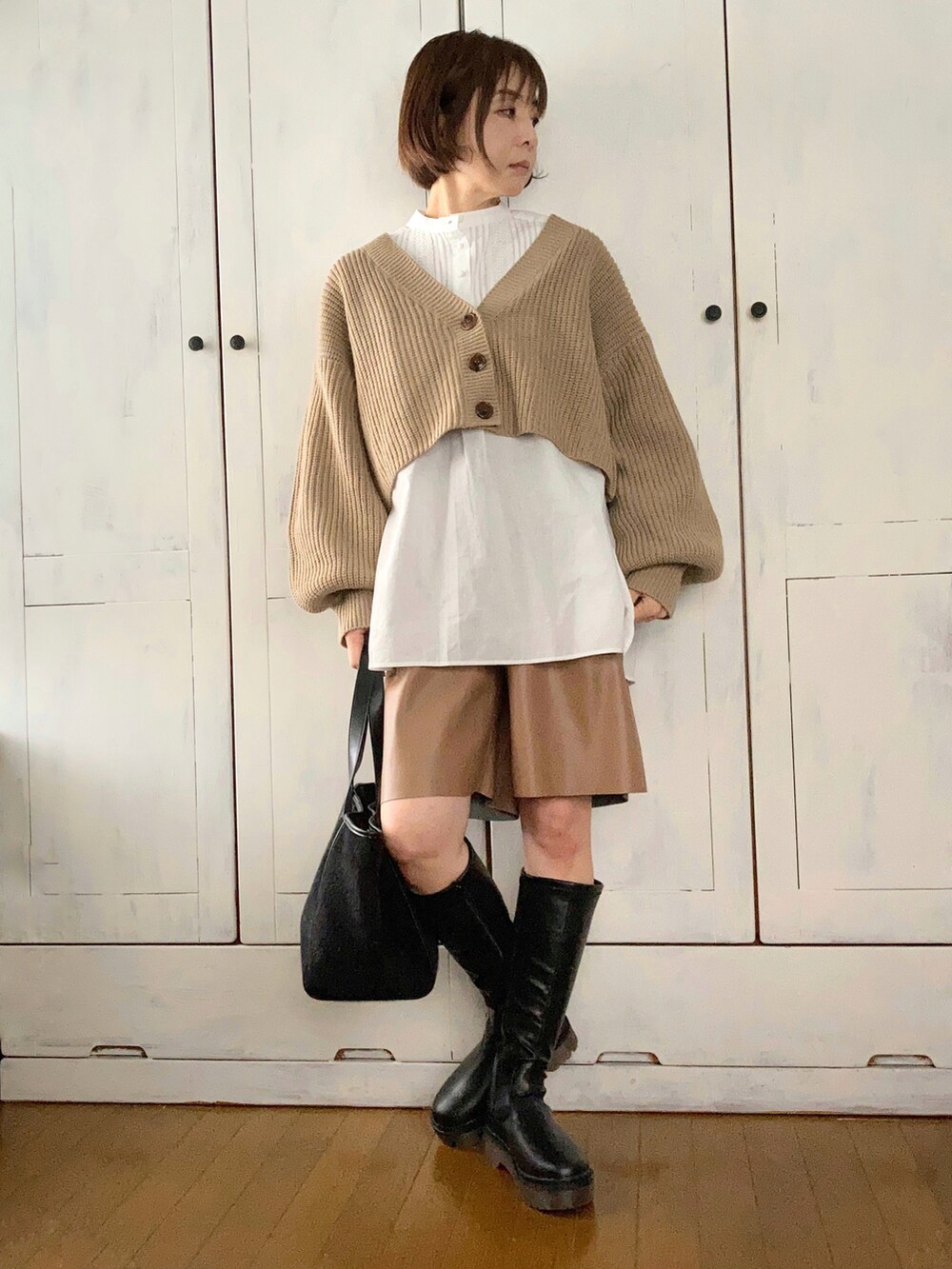 ブルー系のノーカラーコート、ベージュ系のカーディガン/ボレロ、ホワイト系のシャツ/ブラウスを着用したレディースの秋コーディネートの2枚目の写真