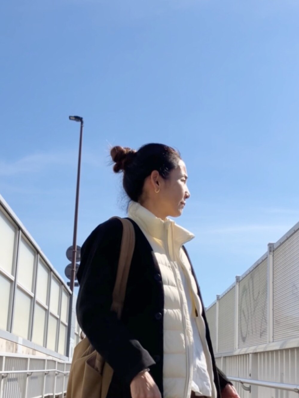 ホワイト系のダウンベストを着用したレディースの秋コーディネートの2枚目の写真