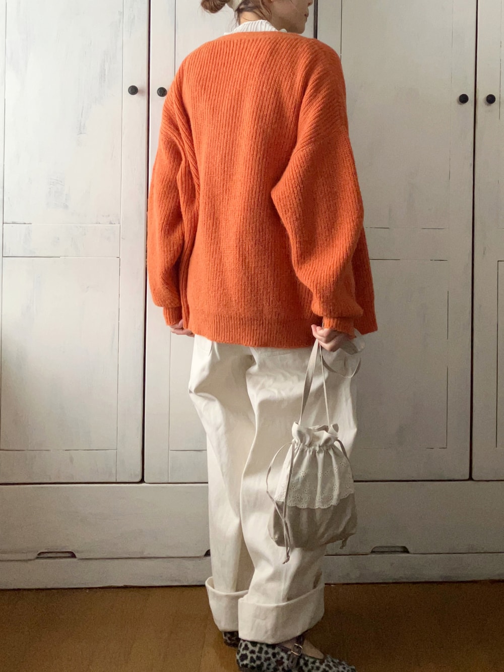 ホワイト系のサロペット/オーバーオール、ホワイト系のTシャツ/カットソー、オレンジ系のカーディガン/ボレロを着用したレディースの冬コーディネートの2枚目の写真