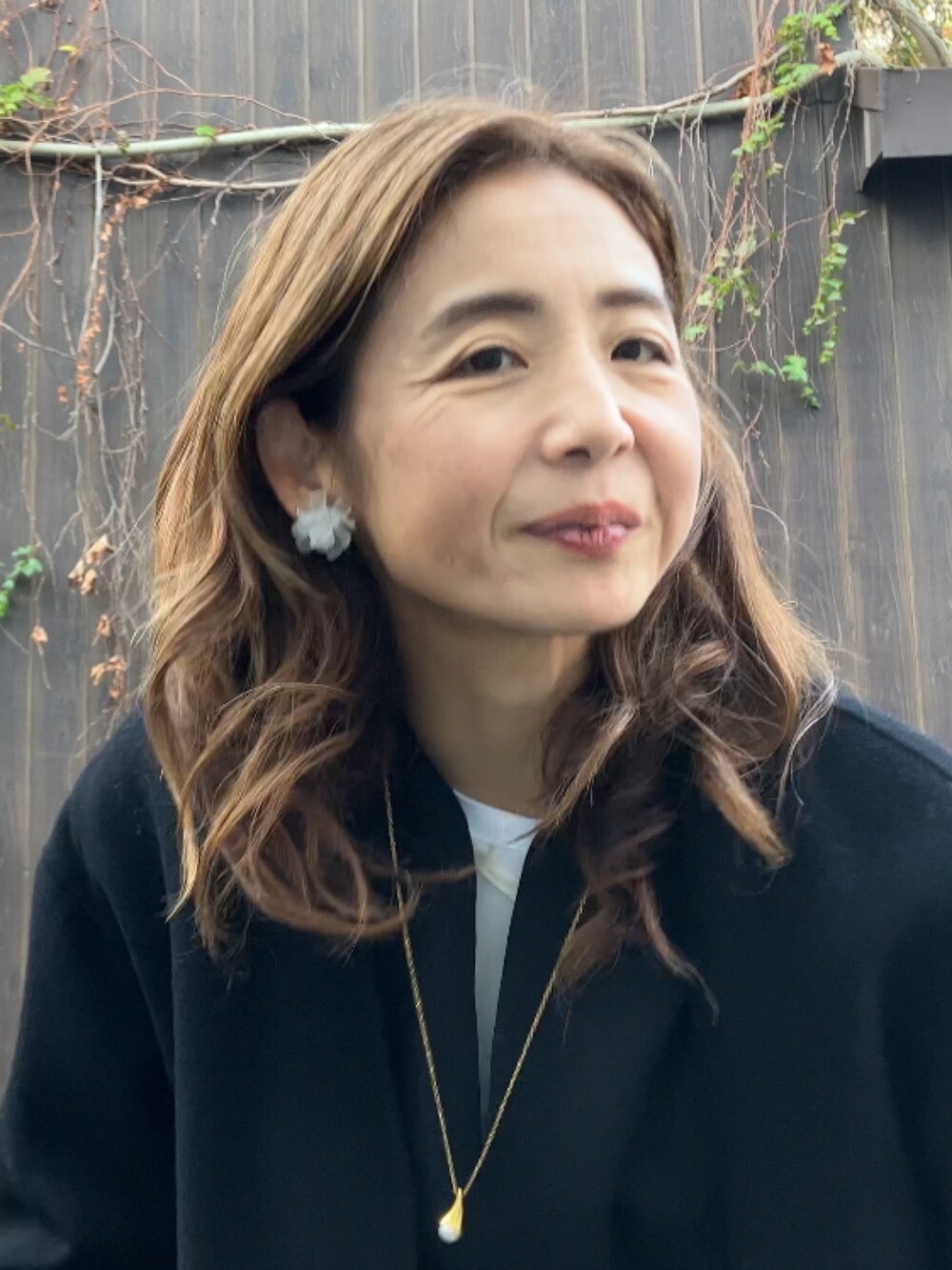 ブラック系のジャンパースカート、ホワイト系のシャツ/ブラウス、ホワイト系のショルダーバッグを着用したレディースの秋コーディネートの2枚目の写真