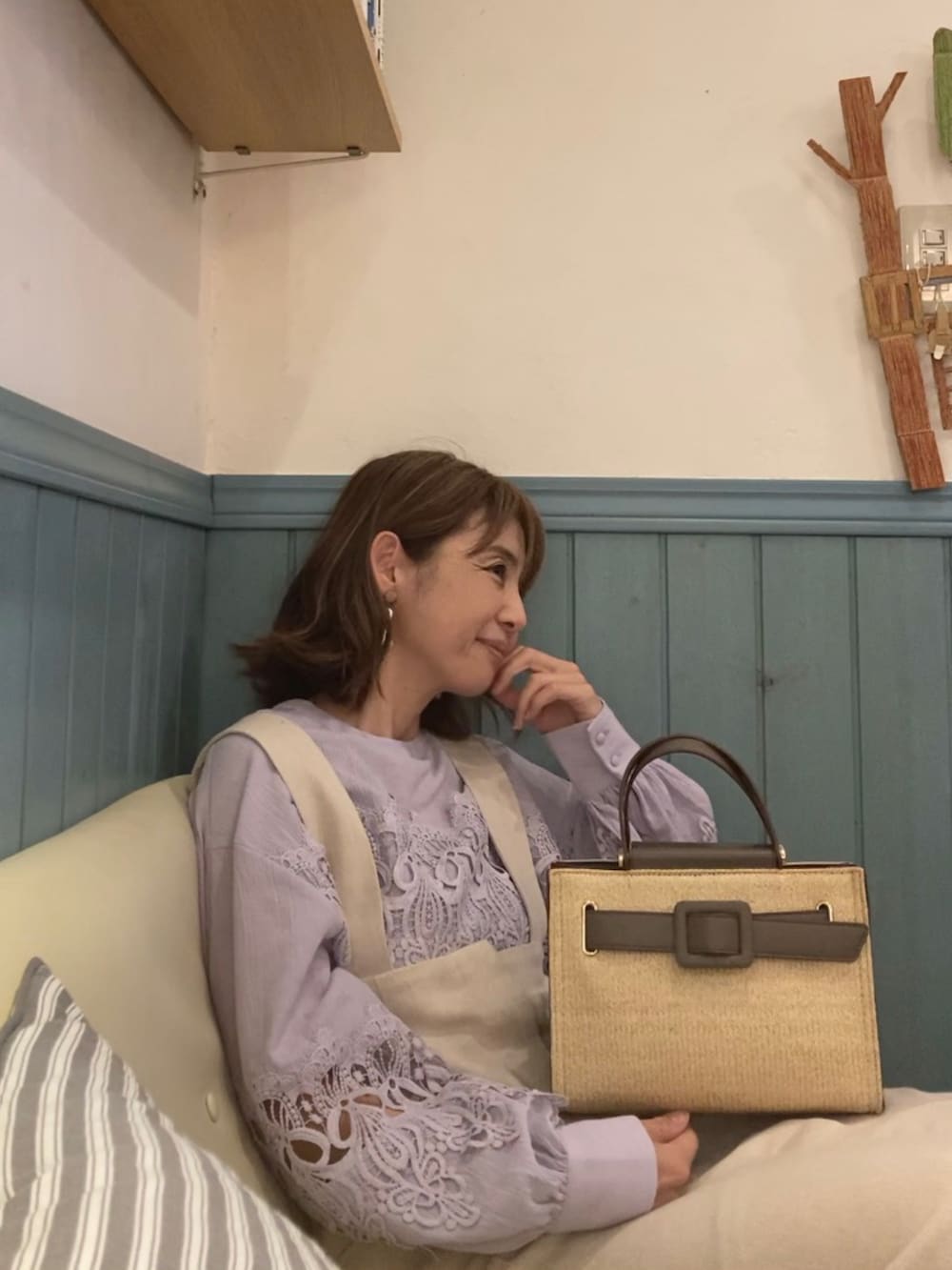 グレー系のハンドバッグ、パープル系のシャツ/ブラウス、ベージュ系のジャンパースカートを着用したレディースの春コーディネートの4枚目の写真