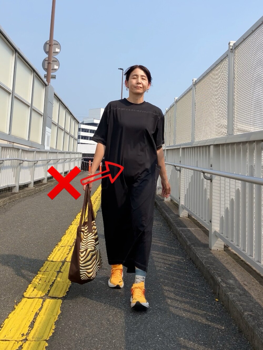 ブラック系のワンピース、ホワイト系のパンツ、ブルー系のキャップを着用したレディースの夏コーディネートの2枚目の写真