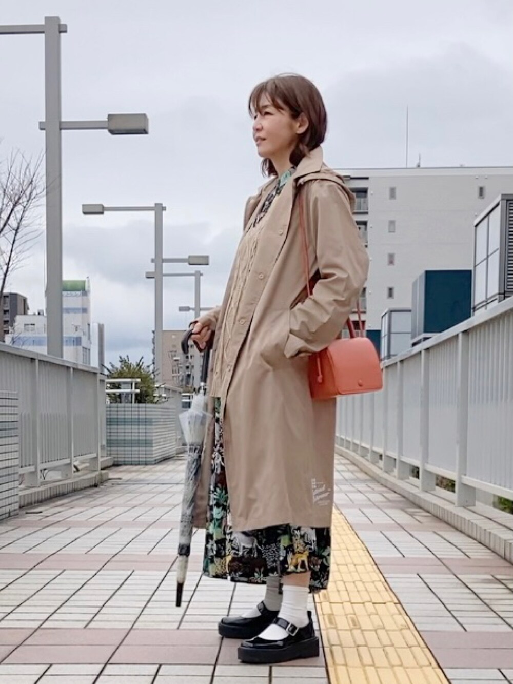 「雨の日コーデ、レインコート、Traditional Weatherwear、トラディショナルウェザーウエア、TWW、春コーデ、オレンジ、動物柄、動物モチーフ、ティアードワンピース」|「Traditional WeatherwearのPENRITH RAIN PACKABLE / パッカブルレインコート(レインコート/ポンチョ、ベージュ系)」を使った、まゆみんさん(レディース・160cm)の春コーディネートの2枚目の写真