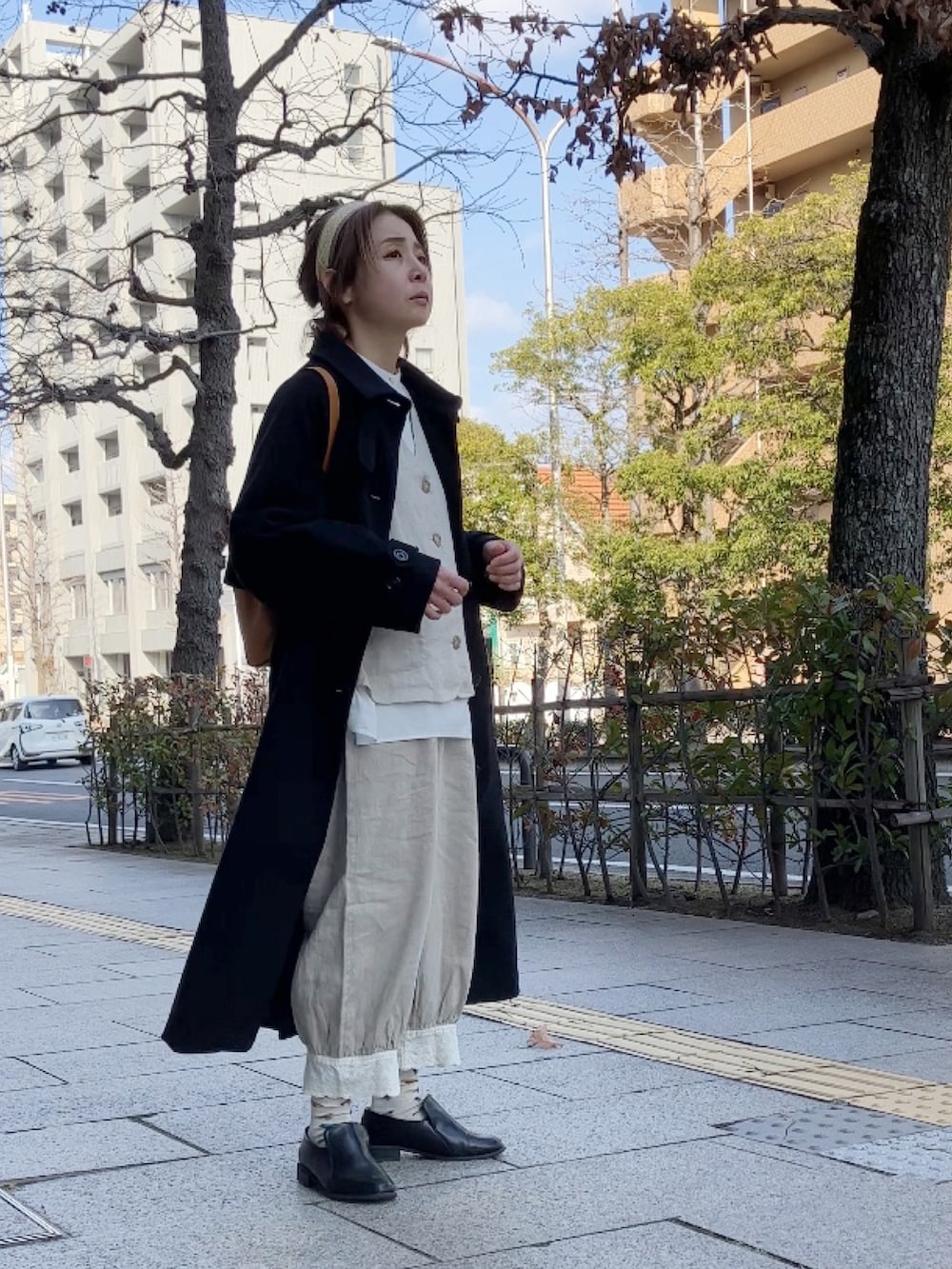 ベージュ系のベスト、ベージュ系のパンツ、ホワイト系のシャツ/ブラウスを着用したレディースの冬コーディネートの4枚目の写真