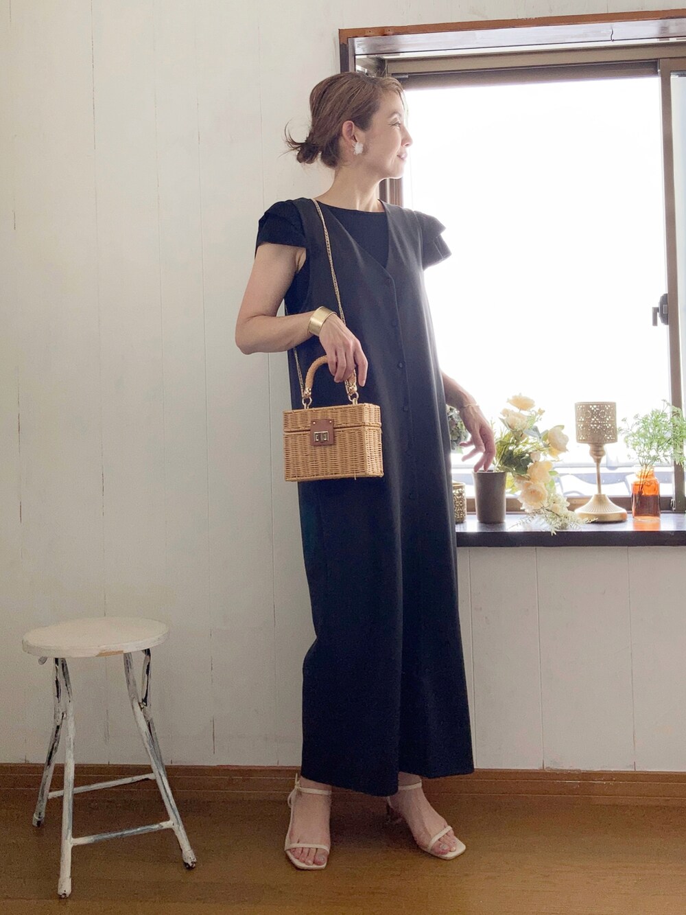 ブラック系のジャンパースカート、ブラック系のニット/セーター、ベージュ系のかごバッグを着用したレディースの夏コーディネートの3枚目の写真