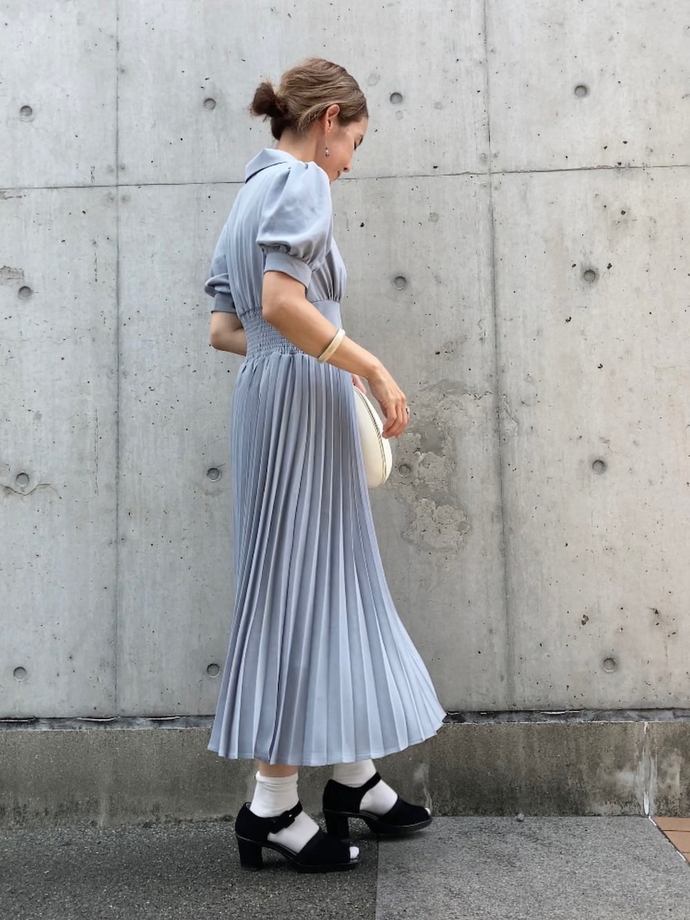 ブルー系のシャツワンピース、ブラック系のサンダル、ホワイト系のバッグを着用したレディースの夏コーディネートの2枚目の写真