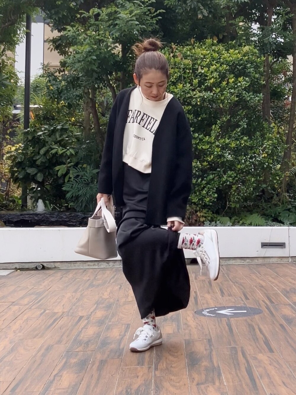 ホワイト系のスウェット、ブラック系のワンピース、ホワイト系のスニーカーを着用したレディースの冬コーディネートの2枚目の写真