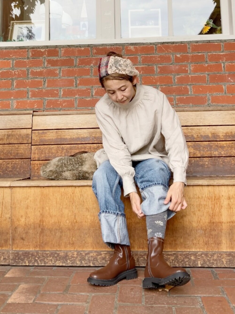 ベージュ系のシャツ/ブラウス、ブルー系のデニムパンツ、ブラウン系のブーツを着用したレディースの秋コーディネートの3枚目の写真