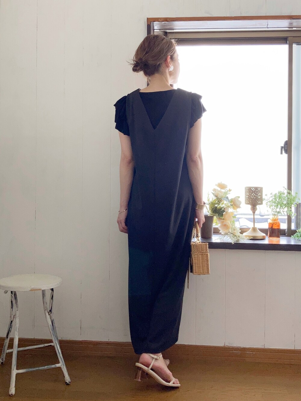 ブラック系のジャンパースカート、ブラック系のニット/セーター、ベージュ系のかごバッグを着用したレディースの夏コーディネートの2枚目の写真