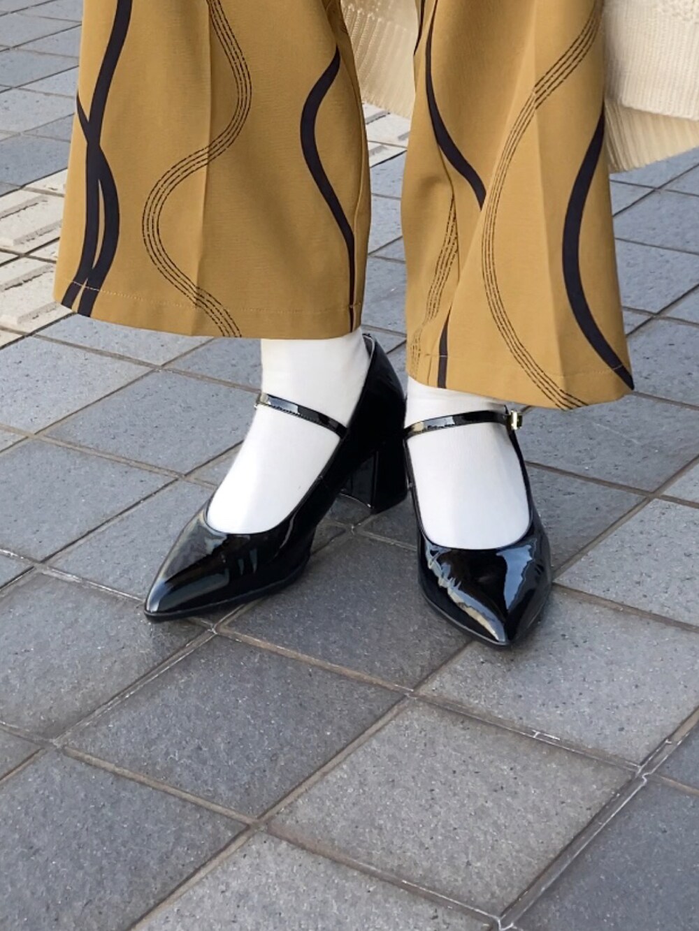 ベージュ系のカーディガン/ボレロ、ブラック系のニット/セーター、イエロー系のその他パンツを着用したレディースの秋コーディネートの2枚目の写真