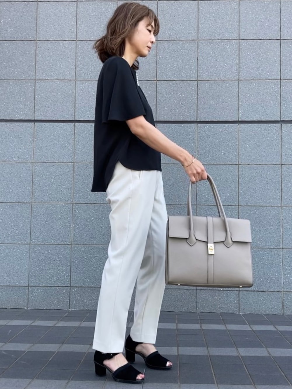 ブラック系のシャツ/ブラウス、ホワイト系のパンツ、ブラック系のサンダルを着用したレディースの春コーディネートの2枚目の写真