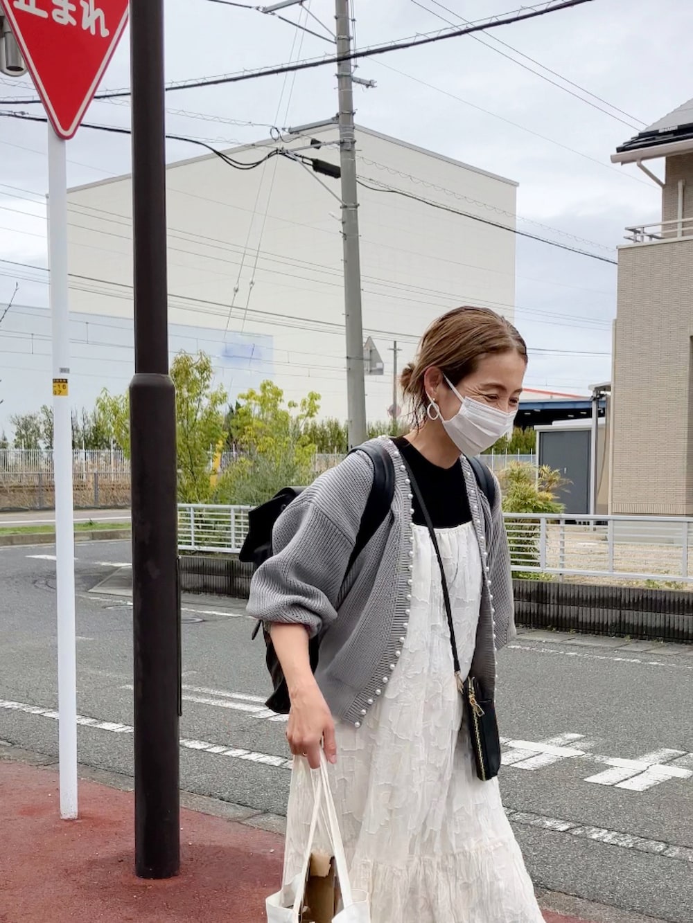 グレー系のカーディガン/ボレロ、ホワイト系のワンピース、ブラウン系のバックパック/リュックを着用したレディースの春コーディネートの4枚目の写真