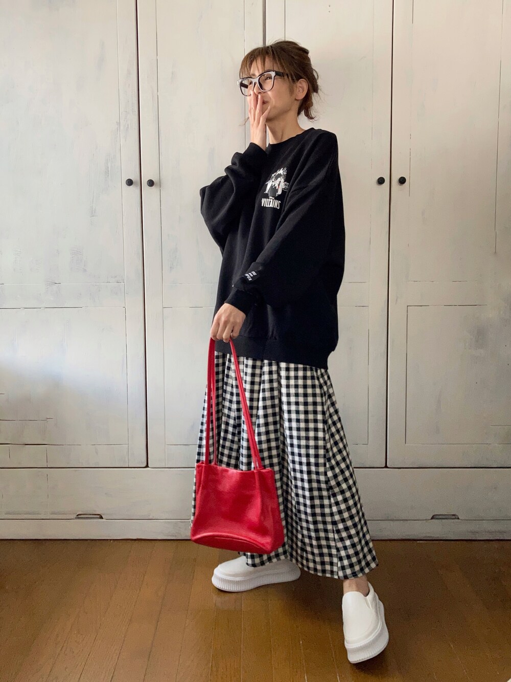 ブラック系のスカート、ブラック系のTシャツ/カットソー、ホワイト系のスリッポンを着用したレディースの春コーディネートの2枚目の写真