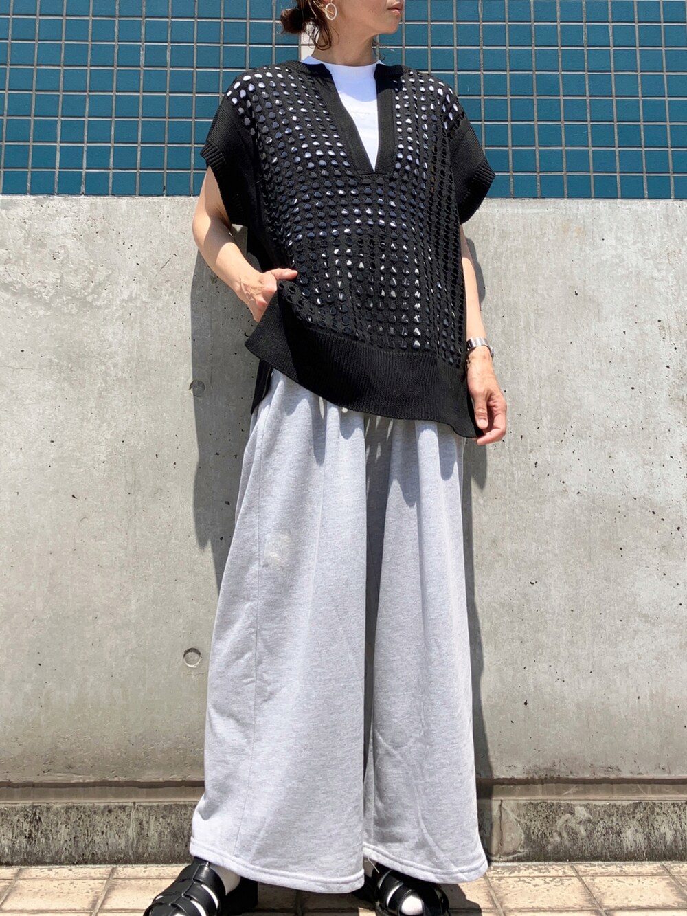 ブラック系のベスト、グレー系のスウェットパンツを着用したレディースの春コーディネートの3枚目の写真