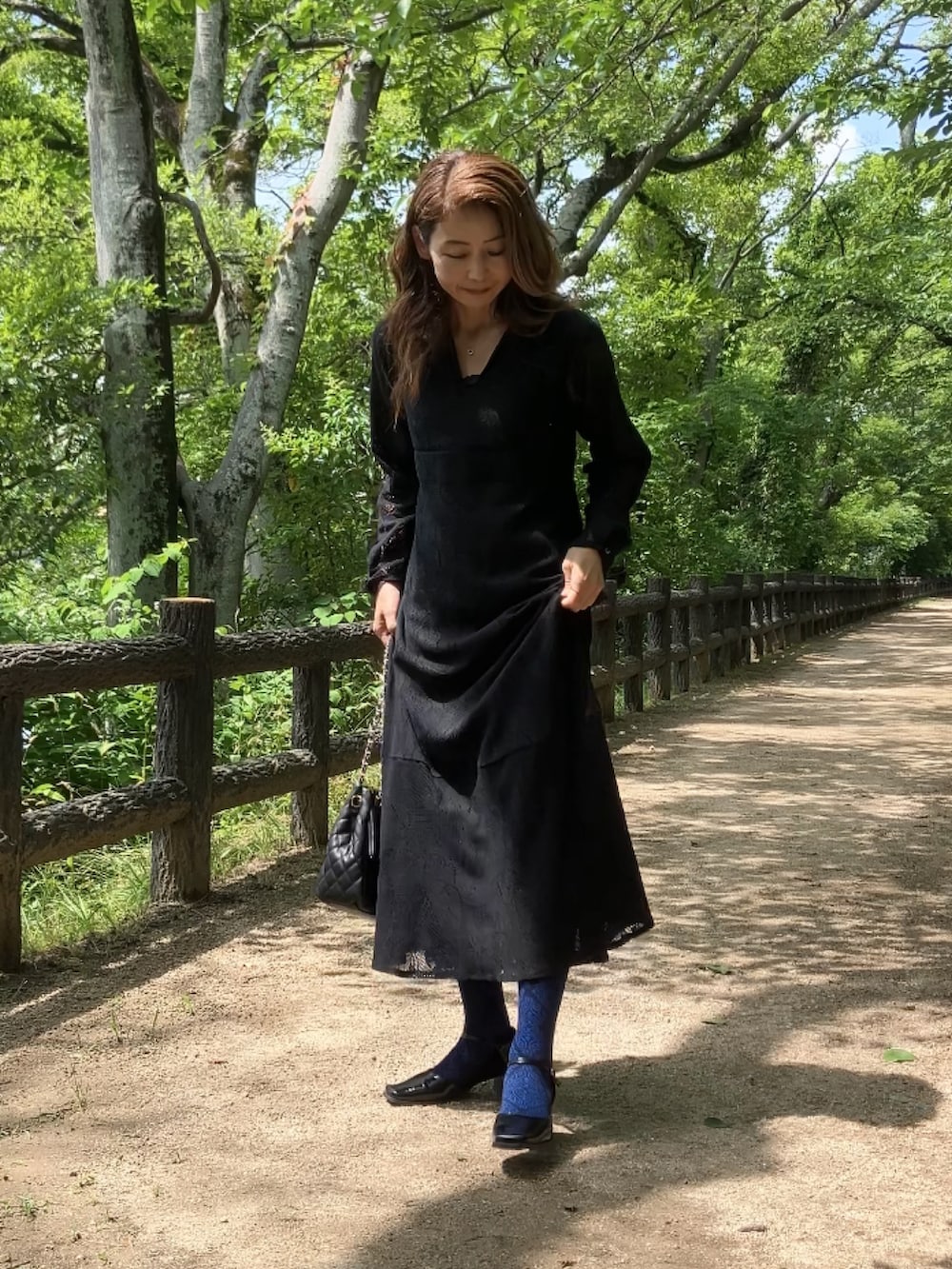 ブラック系のワンピース、ブラック系のボストンバッグ、ブルー系のソックス/靴下を着用したレディースの夏コーディネートの3枚目の写真