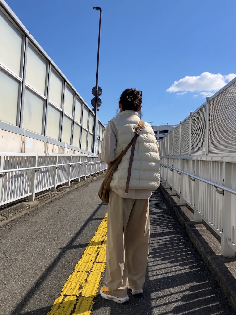 ホワイト系のダウンベストを着用したレディースの秋コーディネートの3枚目の写真