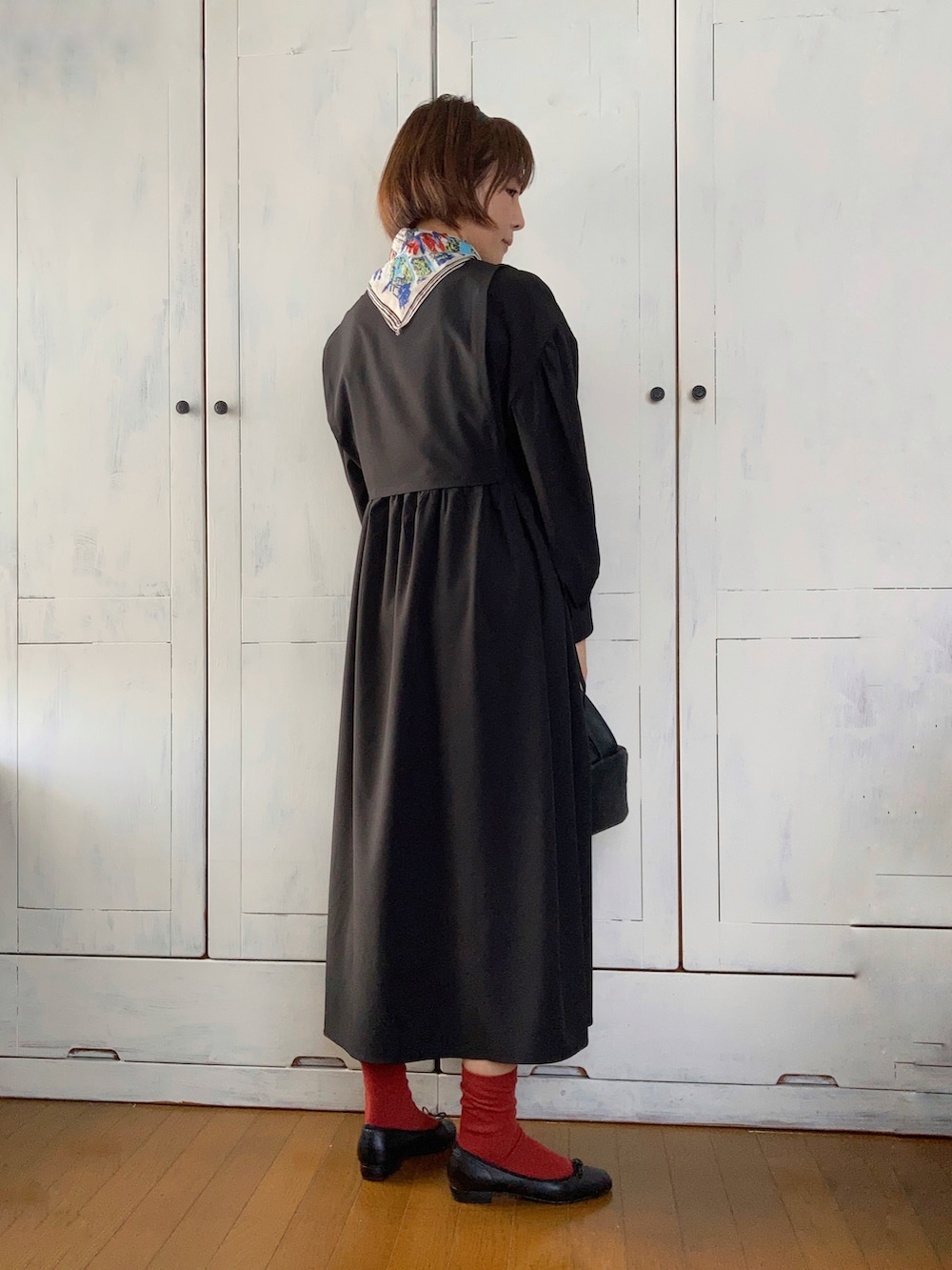 ブラック系のワンピース、ブラック系のハンドバッグ、ブラック系のバレエシューズを着用したレディースの秋コーディネートの2枚目の写真