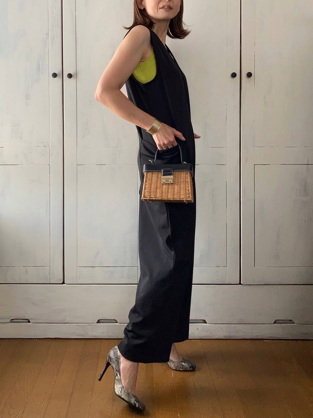 ブラック系のつなぎ/オールインワン、グリーン系のタンクトップ、ブラウン系のかごバッグを着用したレディースの春コーディネートの3枚目の写真