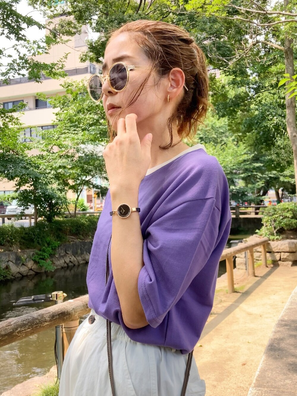 パープル系のTシャツ/カットソー、ホワイト系のチノパンツ、グリーン系のショルダーバッグを着用したレディースの夏コーディネートの2枚目の写真