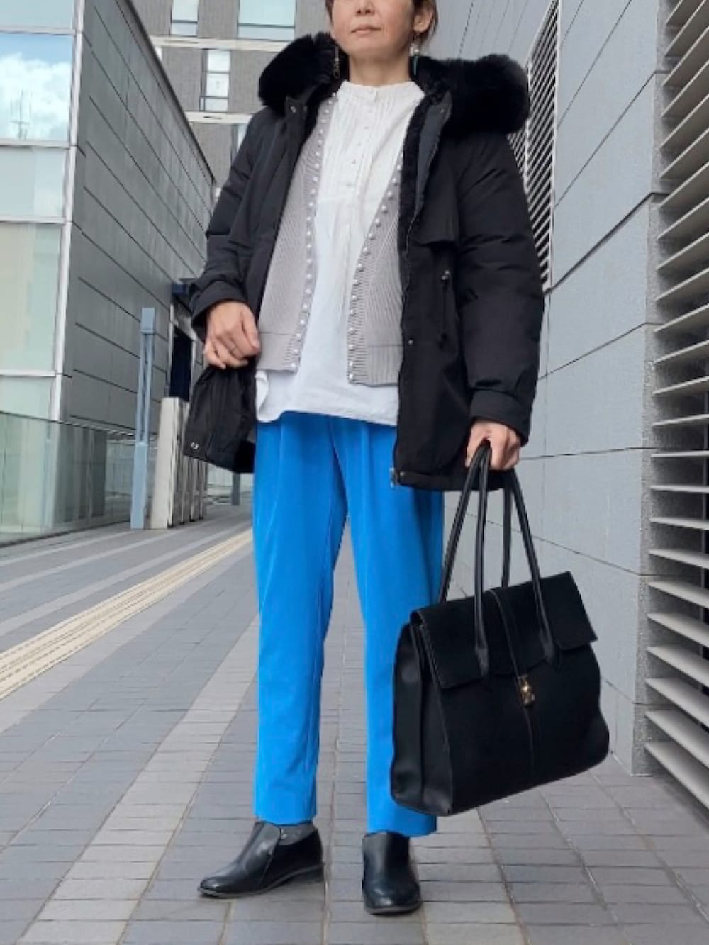 グレー系のカーディガン/ボレロ、ブルー系のその他パンツ、ブラック系のブルゾンを着用したレディースの冬コーディネートの3枚目の写真