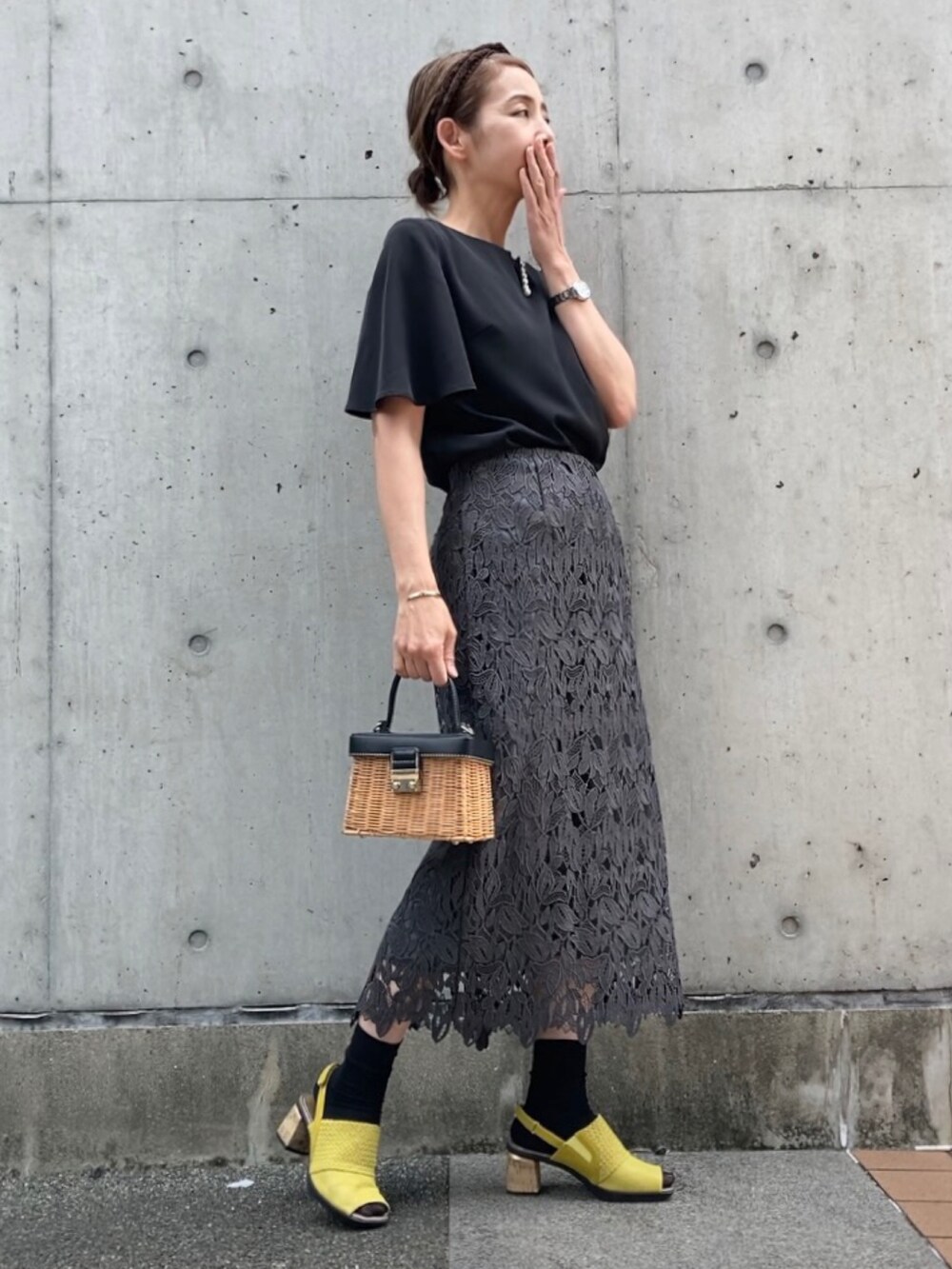 ブラック系のシャツ/ブラウス、イエロー系のサンダル、ブラウン系のかごバッグを着用したレディースの春コーディネートの2枚目の写真