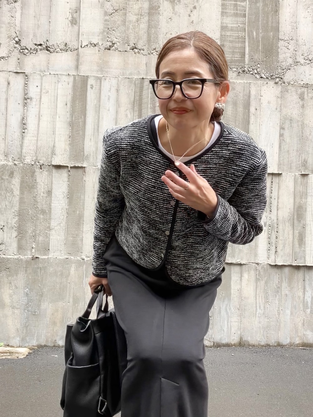 ブラック系のノーカラージャケット、ブラック系のジャンパースカート、ブラック系のバックパック/リュックを着用したレディースの冬コーディネートの2枚目の写真