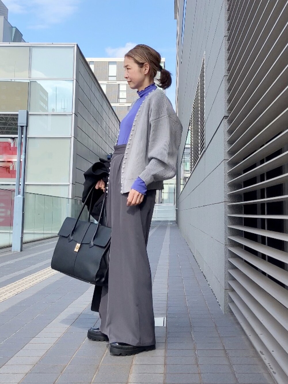 グレー系のカーディガン/ボレロ、ブラック系のステンカラーコート、グレー系のその他パンツを着用したレディースの冬コーディネートの5枚目の写真