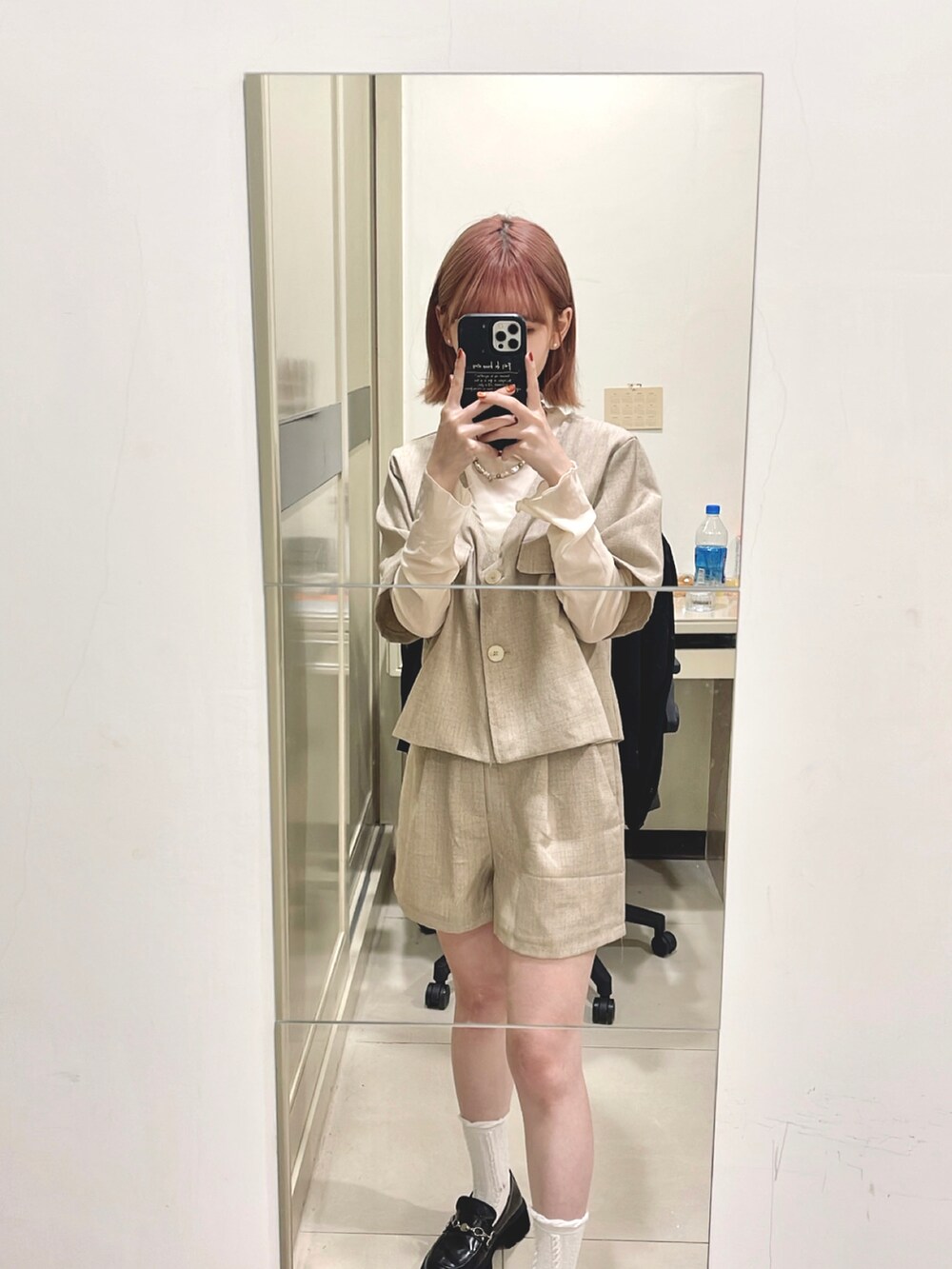 ベージュ系のスーツセットを着用したレディースの秋コーディネートの2枚目の写真