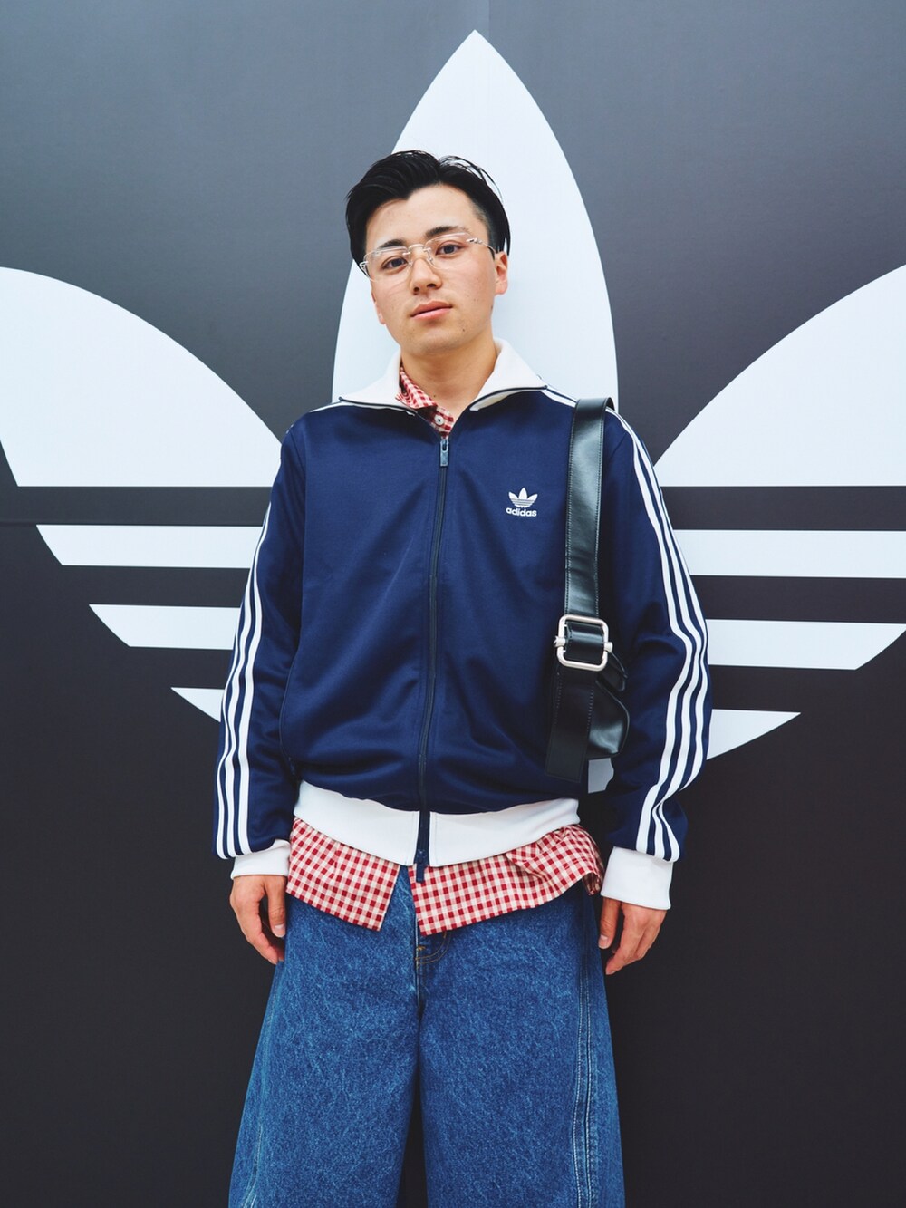 ホワイト系のスニーカー、ブルー系のデニムパンツ、レッド系のシャツ/ブラウスを着用したメンズの秋コーディネートの2枚目の写真