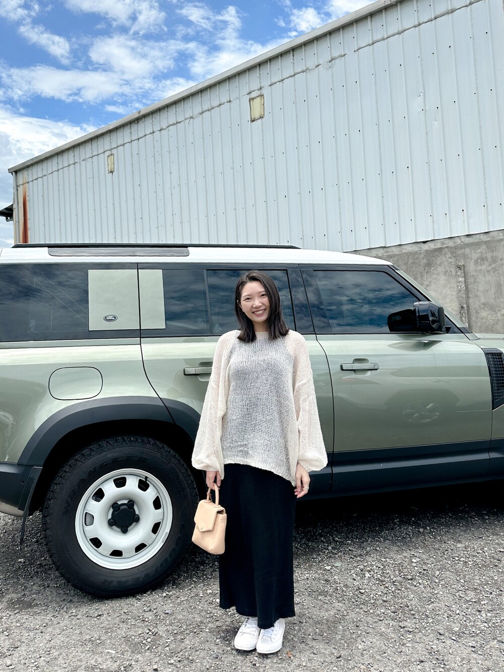 ベージュ系のトートバッグ、ホワイト系のスリッポンを着用したレディースの春コーディネートの2枚目の写真