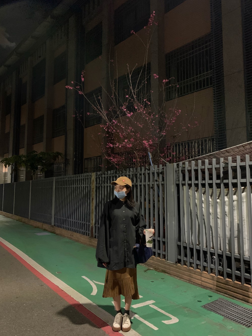 ブラウン系のスリッポン、ブルー系のトートバッグ、ブラウン系のキャップを着用したレディースの春コーディネートの2枚目の写真